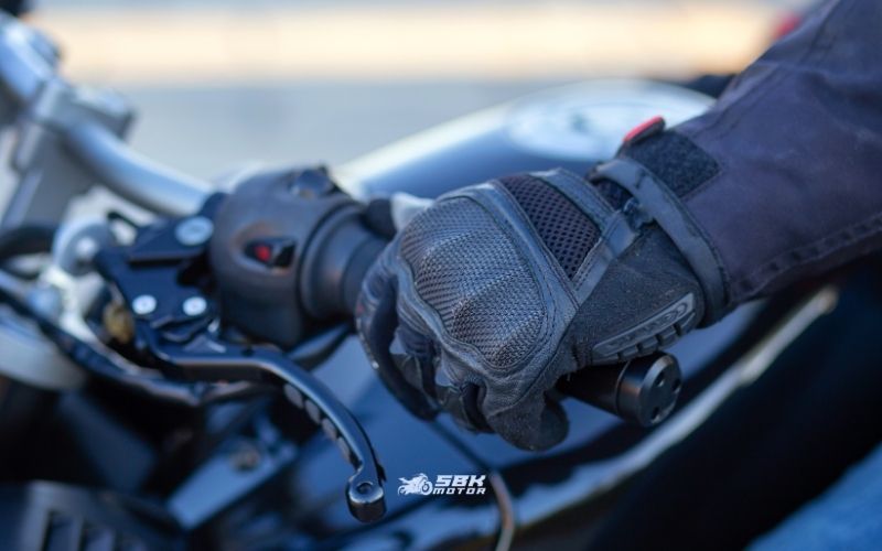 EN 13594 Testleri Ne Ölçer? Standardın hedefi, düşme/sürüklenme/darbe anında elin karşılaşacağı başlıca riskleri denemektir. Test başlıkları, genel EN ISO 21420 koşullarının yanı sıra şunları içerir: aşınma direnci, yırtılma direnci, dikiş patlama/sağlamlık, kesilme direnci, bilekten çıkmayı önleme (retention), ergonomi/çeviklik, ve eklem darbe sönümleme (KP). Level 2 daha yüksek eşikler ister. Knuckle (KP) Darbe Testi: Eldivenin eklem bölgesine yerleştirilen örnek parça, bir örs üzerindeki kubbe üzerine konur ve 2,5 kg kütle 5 Joule darbe uygular. Dört tekrar yapılır; iletim kuvveti (kullanıcıya geçen darbe) sınırın altında kalmalıdır. Level 2 için bu test zorunludur. EN 13594 Testleri Ne Ölçer? Standardın hedefi, düşme/sürüklenme/darbe anında elin karşılaşacağı başlıca riskleri denemektir. Test başlıkları, genel EN ISO 21420 koşullarının yanı sıra şunları içerir: aşınma direnci, yırtılma direnci, dikiş patlama/sağlamlık, kesilme direnci, bilekten çıkmayı önleme (retention), ergonomi/çeviklik, ve eklem darbe sönümleme (KP). Level 2 daha yüksek eşikler ister. Knuckle (KP) Darbe Testi: Eldivenin eklem bölgesine yerleştirilen örnek parça, bir örs üzerindeki kubbe üzerine konur ve 2,5 kg kütle 5 Joule darbe uygular. Dört tekrar yapılır; iletim kuvveti (kullanıcıya geçen darbe) sınırın altında kalmalıdır. Level 2 için bu test zorunludur.